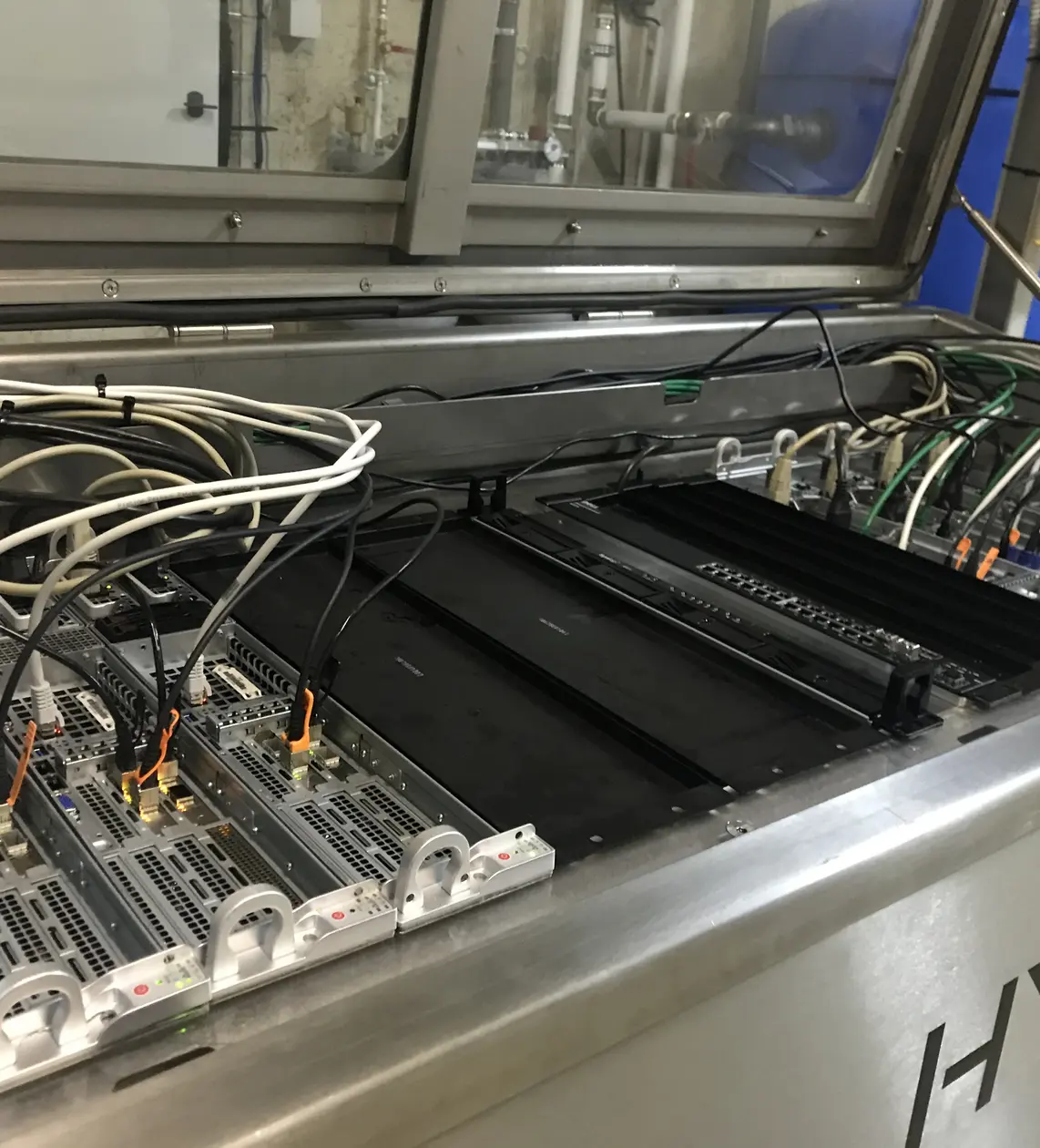 Immersion cooling system with servers submerged in dielectric cooling fluid for thermal management